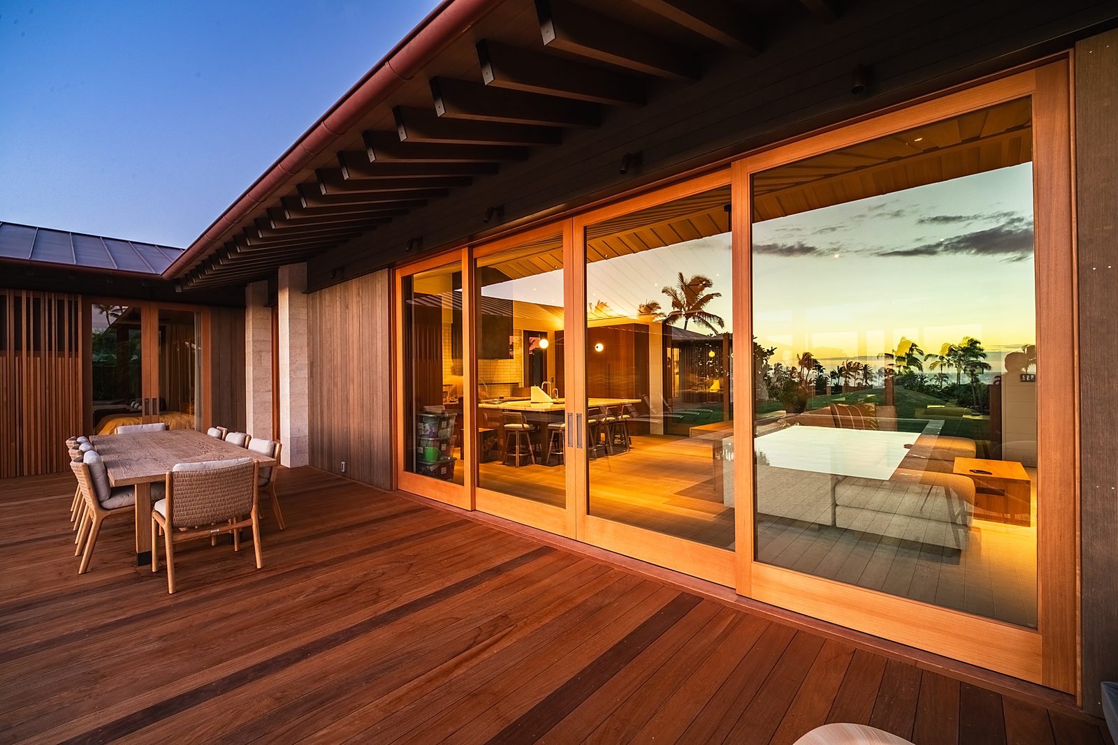 Covered lanai at sunset with the sky reflected in the glass wall